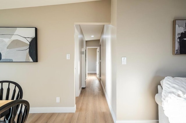 hallway with light hardwood / wood-style floors