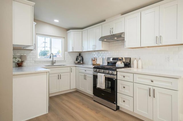 kitchen featuring white cabinetry, sink, light hardwood / wood-style flooring, and stainless steel gas range oven