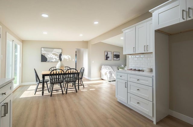 dining area with light hardwood / wood-style floors and vaulted ceiling