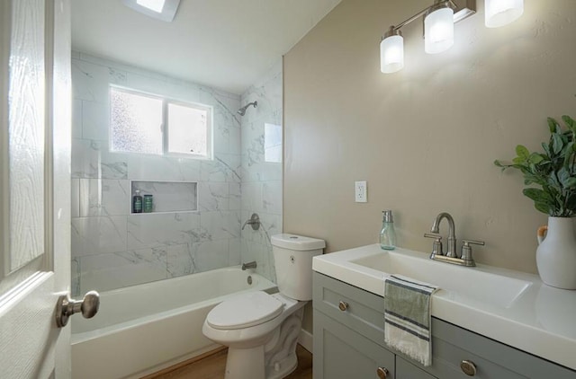 full bathroom featuring vanity, tiled shower / bath combo, and toilet