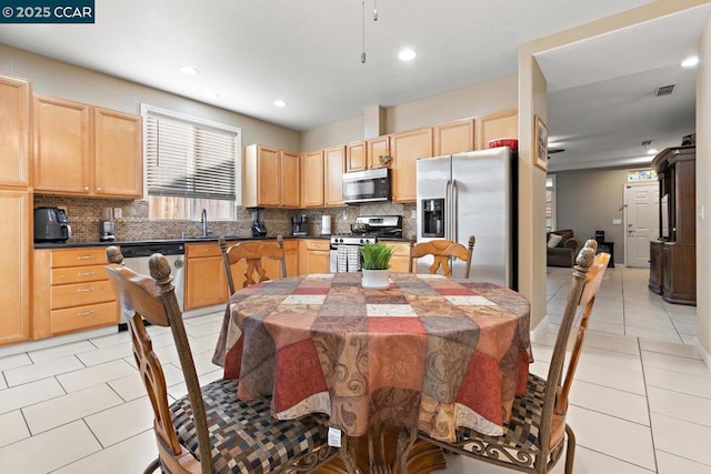 tiled dining room featuring sink