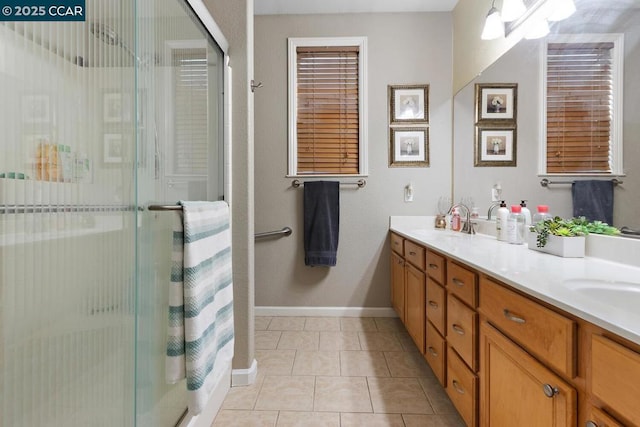 bathroom featuring a shower with shower door, vanity, and tile patterned floors