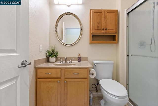 bathroom featuring walk in shower, vanity, tile patterned floors, and toilet