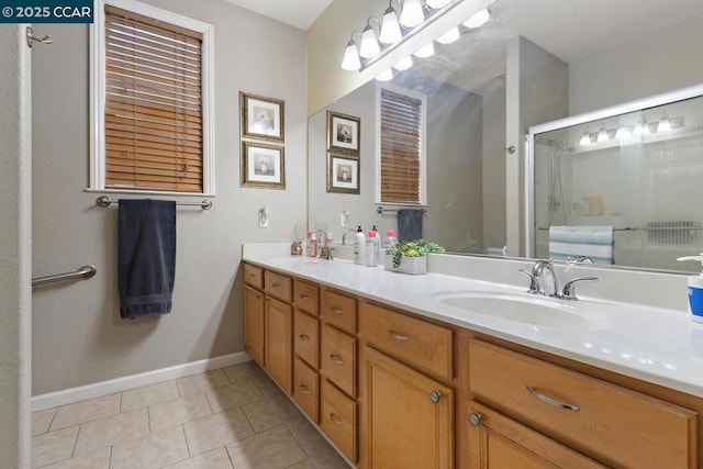 bathroom with a shower with shower door, vanity, and tile patterned flooring