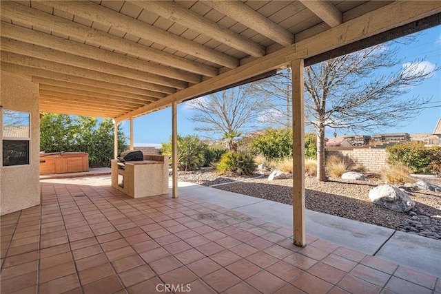 view of patio / terrace with a grill and a hot tub