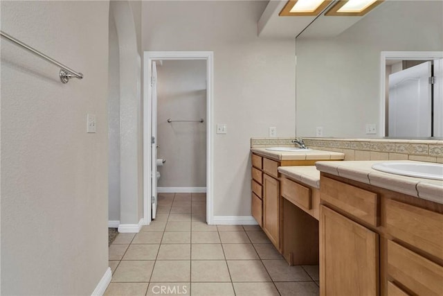 bathroom with toilet, tile patterned flooring, and vanity