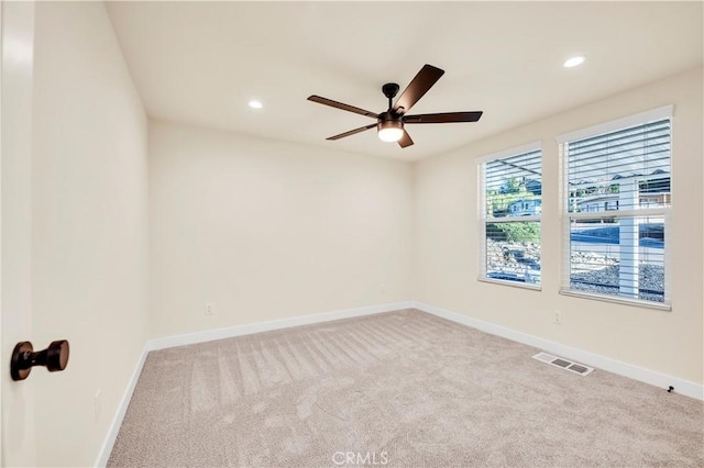 spare room featuring ceiling fan and light carpet