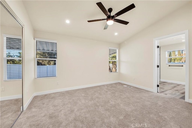 unfurnished bedroom featuring ceiling fan, light colored carpet, and vaulted ceiling