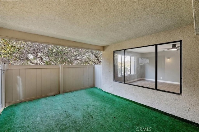 unfurnished sunroom with ceiling fan