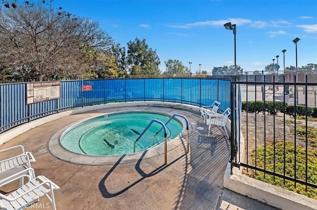 view of swimming pool featuring a hot tub