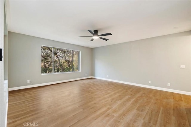 spare room with ceiling fan and light wood-type flooring