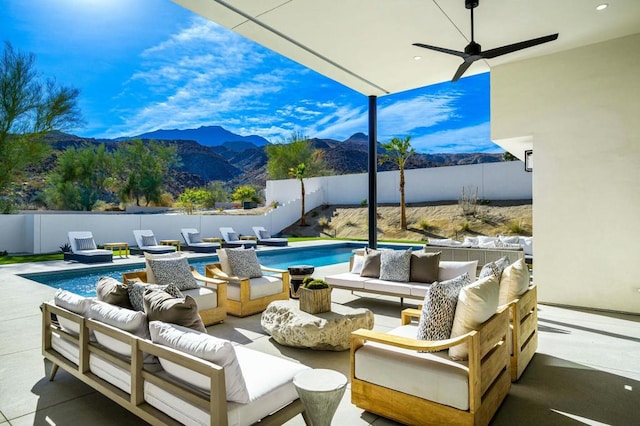 view of patio featuring an outdoor living space, a mountain view, and a fenced in pool