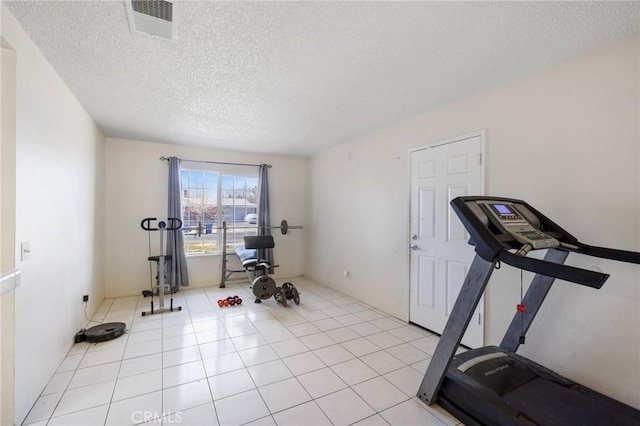 exercise area featuring a textured ceiling and light tile patterned floors