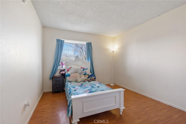 bedroom with a textured ceiling and hardwood / wood-style floors