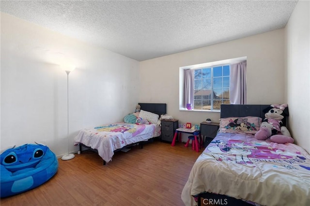 bedroom featuring a textured ceiling and hardwood / wood-style floors