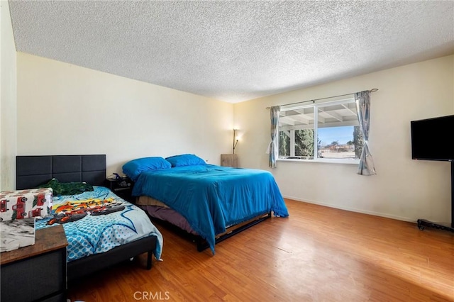 bedroom featuring a textured ceiling and hardwood / wood-style floors