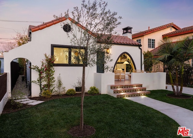 mediterranean / spanish home featuring a lawn