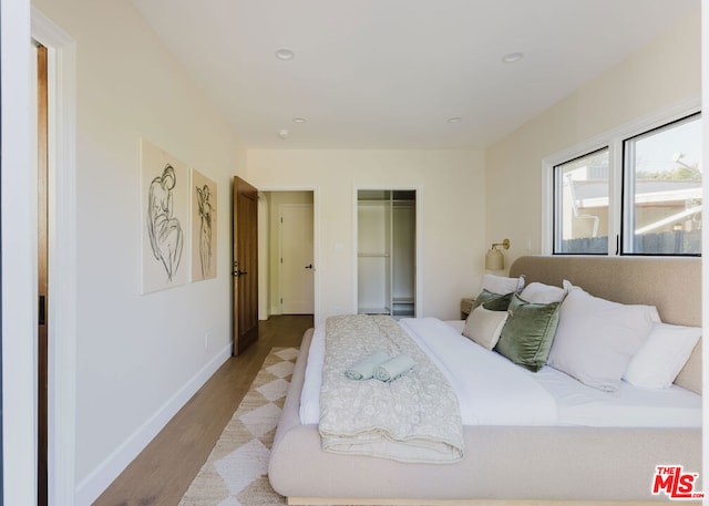 bedroom with light hardwood / wood-style floors and a closet