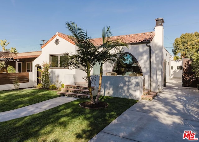 mediterranean / spanish-style house featuring a front lawn