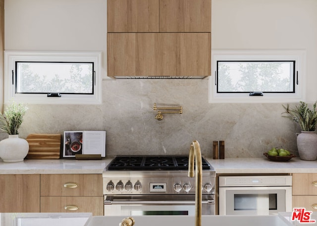 kitchen featuring white oven, high end stove, and tasteful backsplash