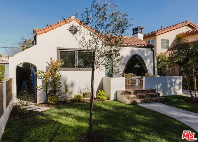 mediterranean / spanish-style house featuring a front yard