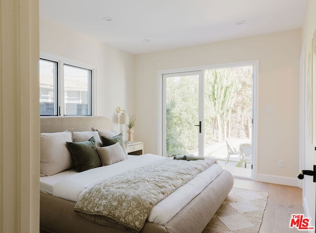 bedroom with access to exterior and light hardwood / wood-style flooring