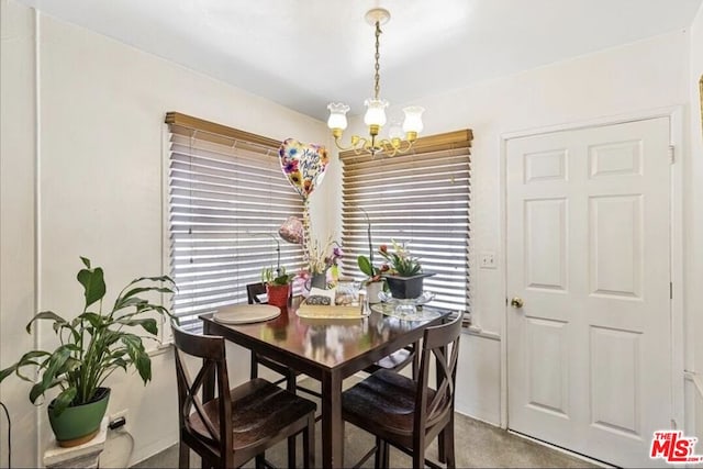 carpeted dining area featuring a chandelier