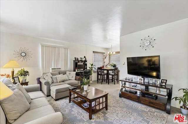 living room with light colored carpet and an inviting chandelier