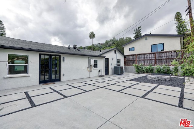 view of patio with central air condition unit and a fire pit