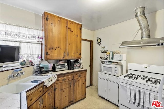 kitchen with ventilation hood and white appliances