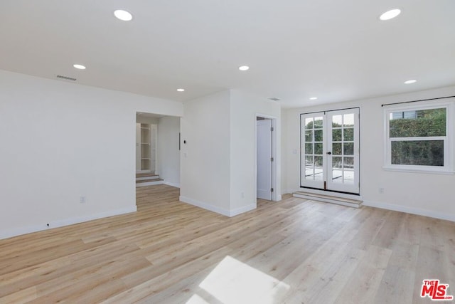 unfurnished room with light wood-type flooring and french doors