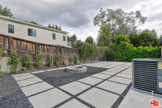 view of patio / terrace with central AC unit and a fire pit