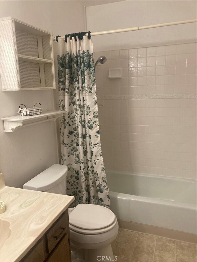 full bathroom with shower / tub combo with curtain, toilet, vanity, and tile patterned flooring