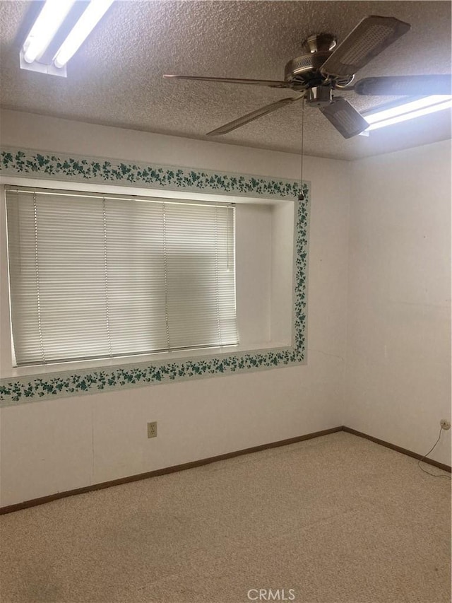 carpeted empty room featuring a textured ceiling and ceiling fan