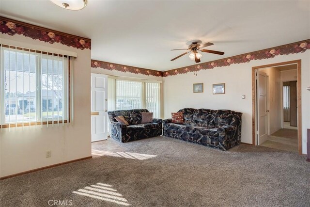 living room featuring ceiling fan and carpet