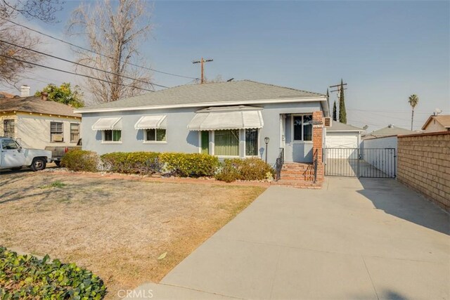 view of front of house featuring a garage and an outbuilding