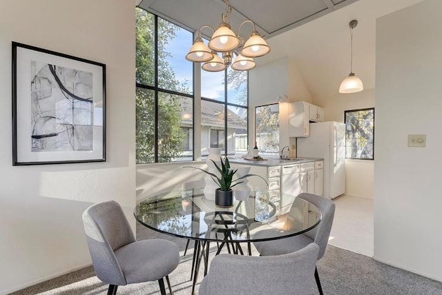 carpeted dining area featuring a high ceiling, sink, and a notable chandelier