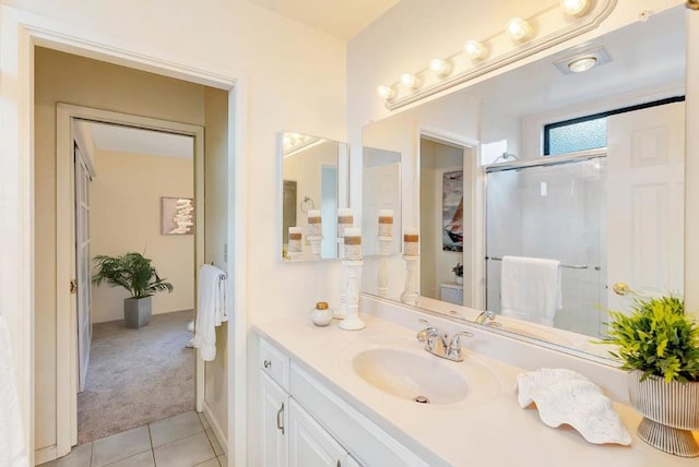 bathroom featuring tile patterned flooring, vanity, and an enclosed shower