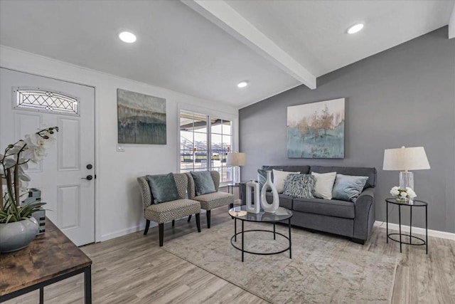 living room with vaulted ceiling with beams and light hardwood / wood-style flooring