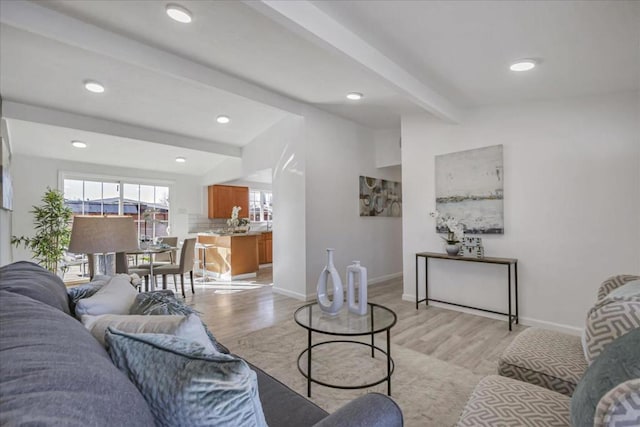 living room featuring beam ceiling and light wood-type flooring