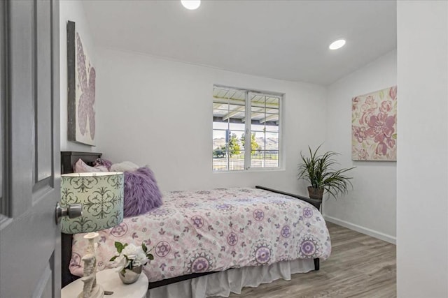 bedroom with wood-type flooring and lofted ceiling