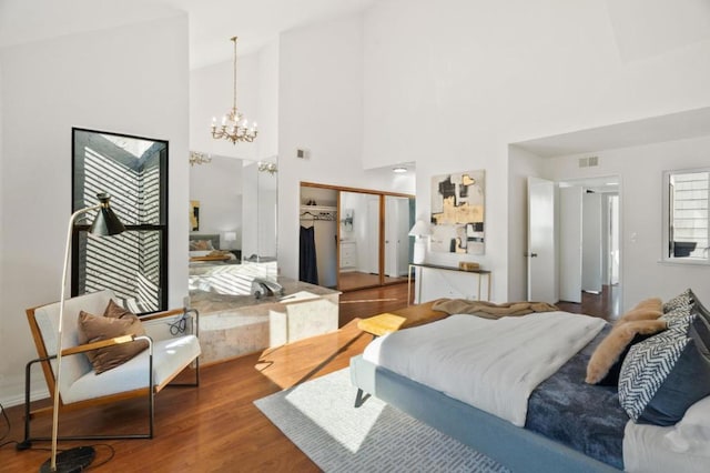 bedroom featuring dark hardwood / wood-style flooring, a notable chandelier, and a closet