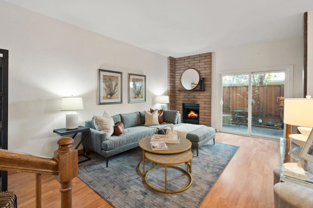 living room featuring a brick fireplace and light hardwood / wood-style flooring