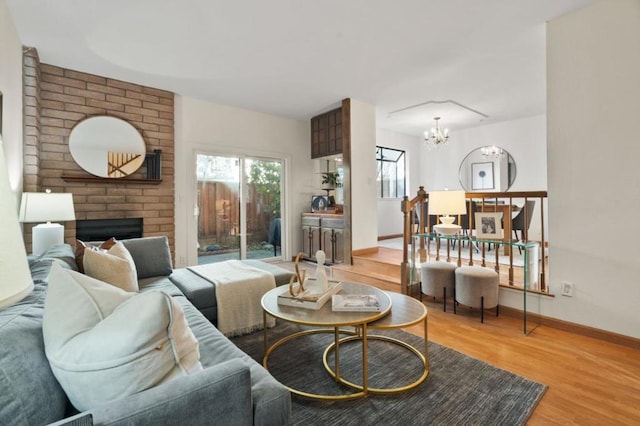 living room featuring a fireplace, a chandelier, and light hardwood / wood-style floors