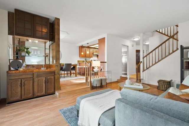 living room featuring indoor bar and light hardwood / wood-style flooring