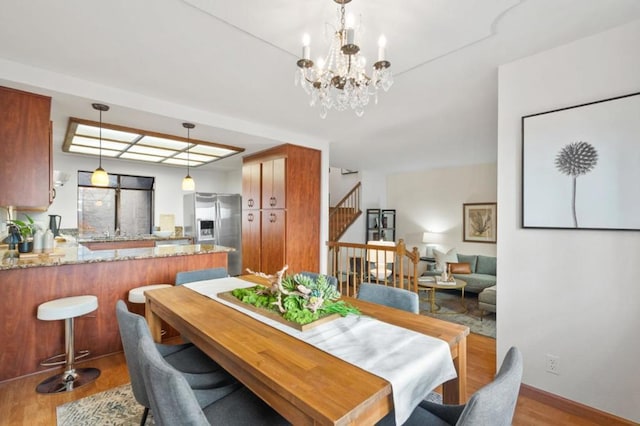 dining space with hardwood / wood-style floors and a chandelier