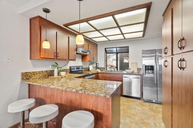 kitchen with stainless steel appliances, light stone counters, a kitchen bar, decorative light fixtures, and kitchen peninsula