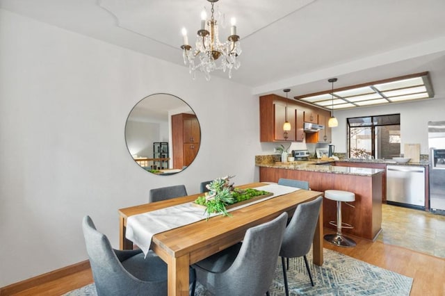 dining space featuring a notable chandelier and light hardwood / wood-style floors