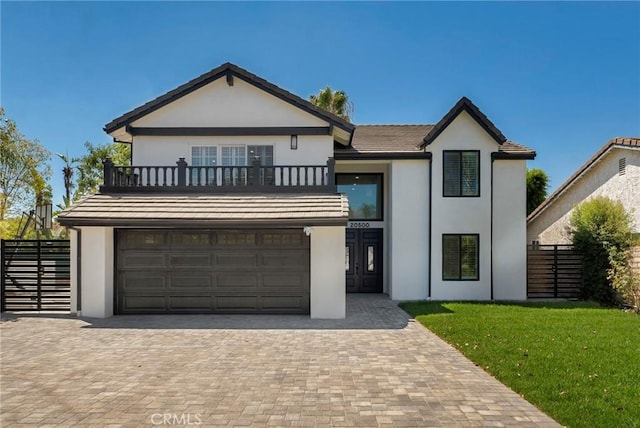 view of front of property featuring a garage, a front lawn, and a balcony