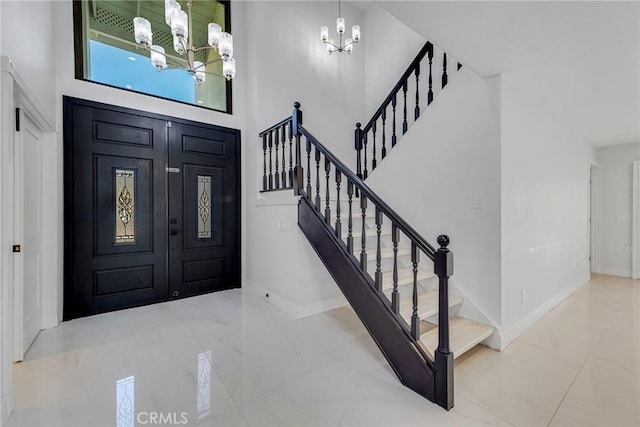 foyer entrance with an inviting chandelier and a towering ceiling